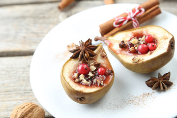 Baked pears with honey, walnuts and cranberries on grey wooden t