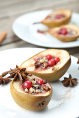 Baked pears with honey, walnuts and cranberries on grey wooden t