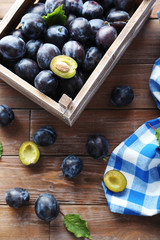 Tasty and ripe plums on brown wooden table