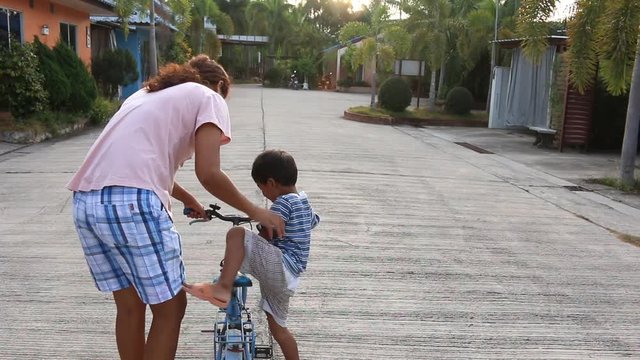 Mother teaching her son to ride a bike