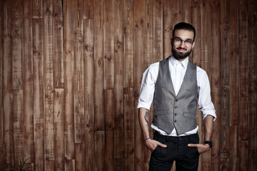 stylish man in formal clothing on a wooden background, place for