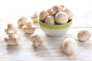 Fresh champignons at white rustic table