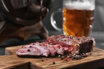 Wall murals Steakhouse Tasty grilled steak with beer on cutting board
