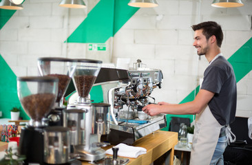 Handsome male barista making coffee