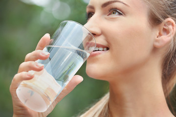 Beautiful girl drinking water on street