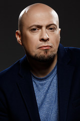 Obraz premium Close up portrait of handsome confident middle-aged businessman over black background.