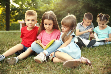 Fototapeta na wymiar Group of happy kids reading books in park