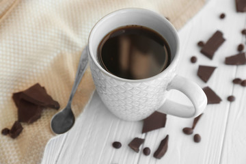 Cup of coffee with chocolate pieces on table