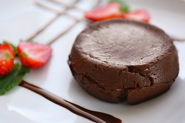 Chocolate fondant with strawberry on plate, closeup