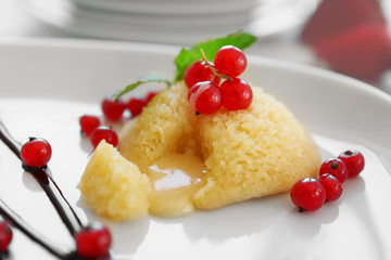 Delicious fondant with red currant on plate, closeup