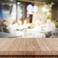 Empty wood table and blurred cafe with bokeh light background