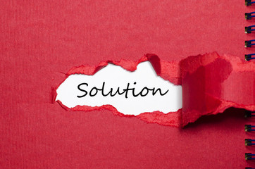 The word solution appearing behind torn paper