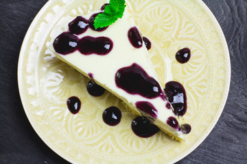 Piece of cheesecake on a black wooden background 