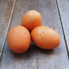 Close up of fresh eggs with water drop on a wooden table.