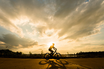 Obraz premium Silhouette of cyclist motion on sunset background