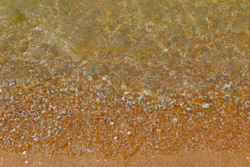 Wave Transparent Sea Water over Sand beach with Small Pebbles background