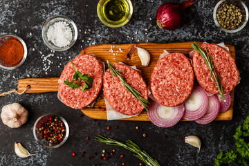 Raw ground beef meat steak cutlets with herbs and spices.