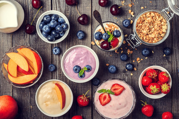 Fototapeta na wymiar Homemade yogurt with fresh strawberry, blueberry, peach on a woo