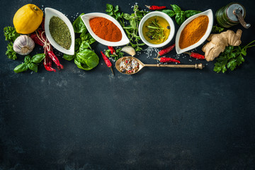 Herbs and spices over black stone background