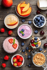 Homemade yogurt with fresh strawberry, blueberry, peach on a woo