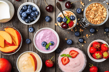 Homemade yogurt with fresh strawberry, blueberry, peach on a woo