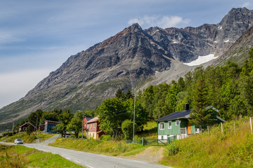 Scandinavian landscape with colorful wooden houses and a glacier