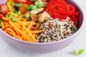 Quinoa bowl with raw vegetables and nuts. Superfoods and clean eating concept. Selective focus