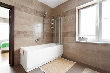 Fototapeta na wymiar White bathtub in large bathroom