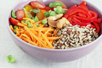 Quinoa bowl with raw vegetables and nuts. Superfoods and clean eating concept. Selective focus