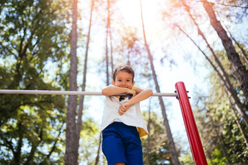 Fototapeta premium Cute little boy playing in a park.