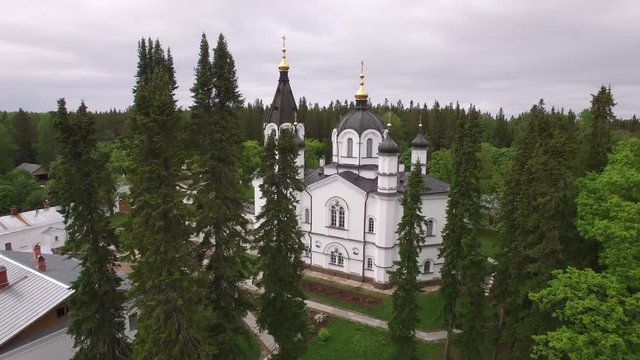 The Skete of All Saints. Valaam Island, Karelia from above. Monastery dramatic aerial drone video. Unique Russian historical and religion tourism place. Lake Ladoga. Pine forest. 4K footage.