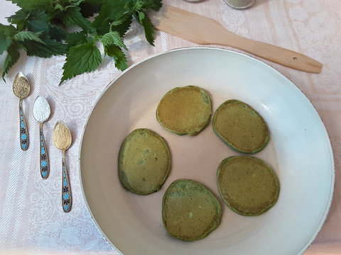 Cooking green pancakes with nettle and ground spices, organic food