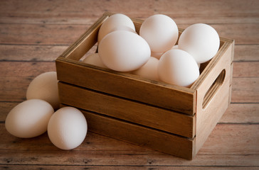 Wooden Crate of Fresh Eggs on a wood plank background board