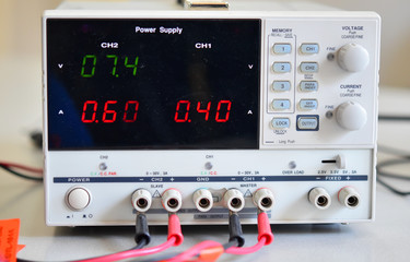 A white power supply with black display on a desk