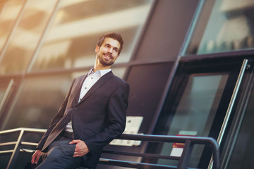 Portrait of a young happy businessman outside the office building