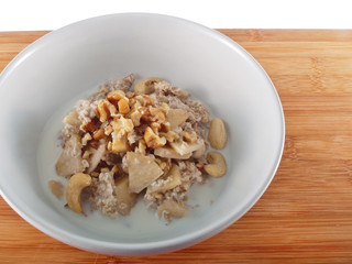 a bowl of oatflakes in soy milk with apple slices and nuts