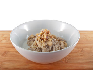 a bowl of oatflakes in soy milk with apple slices and nuts