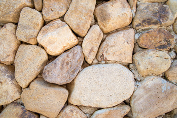 Close-up detail of an orange-white stone wall, as a part of exterior design. Architectural background concept.