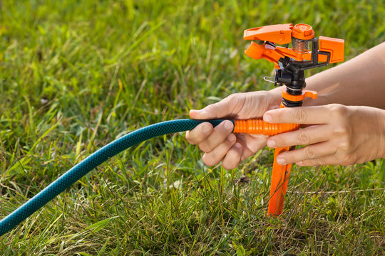 hands of gardener installing sprinkler for irrigation of lawn