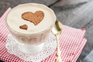dessert tiramisu decorated with hearts on a red napkin and a gol © tanacha