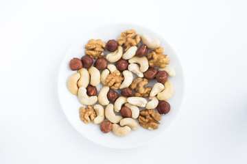 Mixture of cashews, walnuts and hazelnuts on a white plate