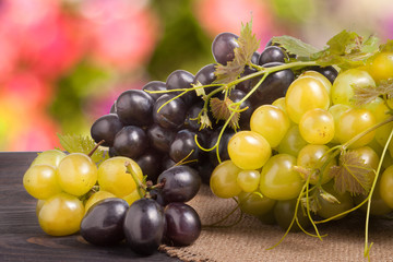 Blue and green grapes on wooden table with a blurred background