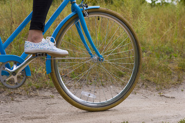 Fototapeta premium Close up of Young Woman Riding Vintage Bicycle in Forest