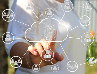 The woman presses on the cloud icon with the technology of fingerprints on the touch screen. Security of data storage .The use of new technologies and business outside the city.Web icons.