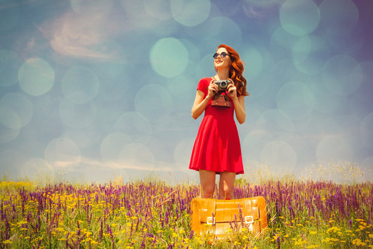 young woman with suitcase and camera