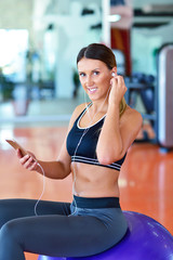 Sportswoman using a mobile phone in the gym.