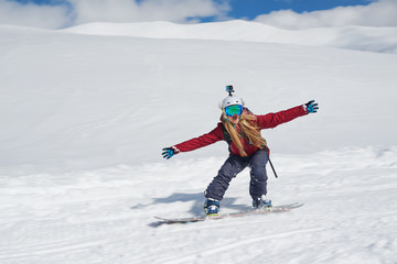 girl snowboarder goes quickly down the slope and shouts
