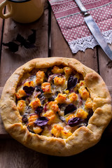 Galette with cheese on wooden table.