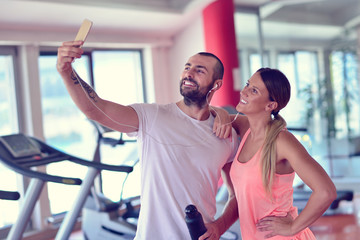 Fototapeta na wymiar Young couple taking a sefie in a gym