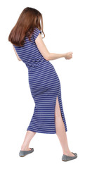 back view of standing girl pulling a rope from the top or cling to something. girl  watching. Rear view people collection.  backside view of person.  Isolated over white background. The brunette in a